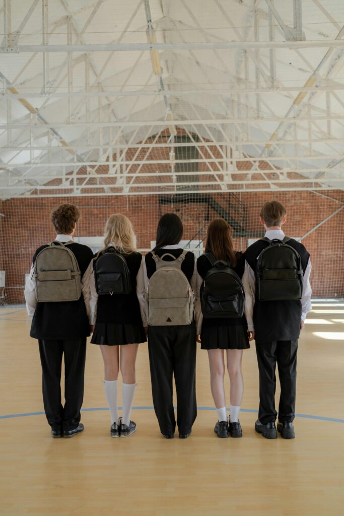 5 high school children standing side by side in a gym.